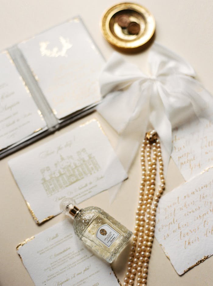 Mastering the First Impression: Your intriguing post title goes here Sophisticated arrangement featuring luxury perfume, pearls, and elegant invitations.